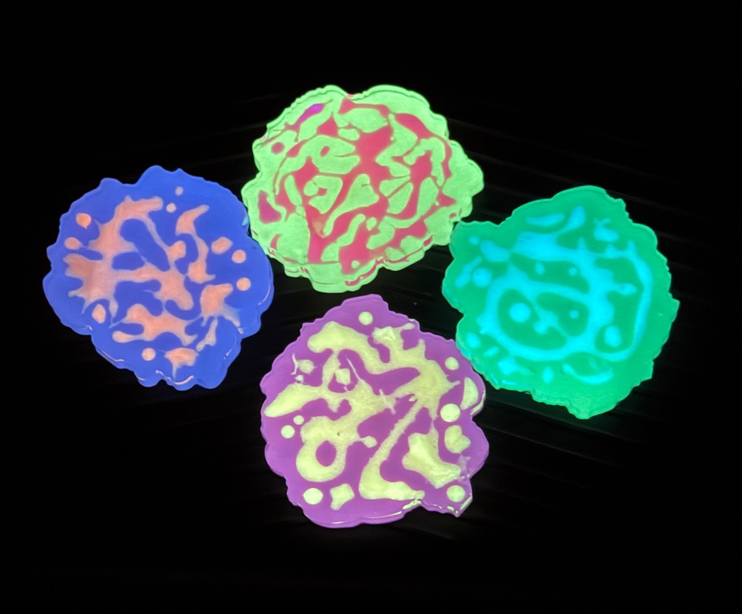 Neon blob coasters glowing under UV light