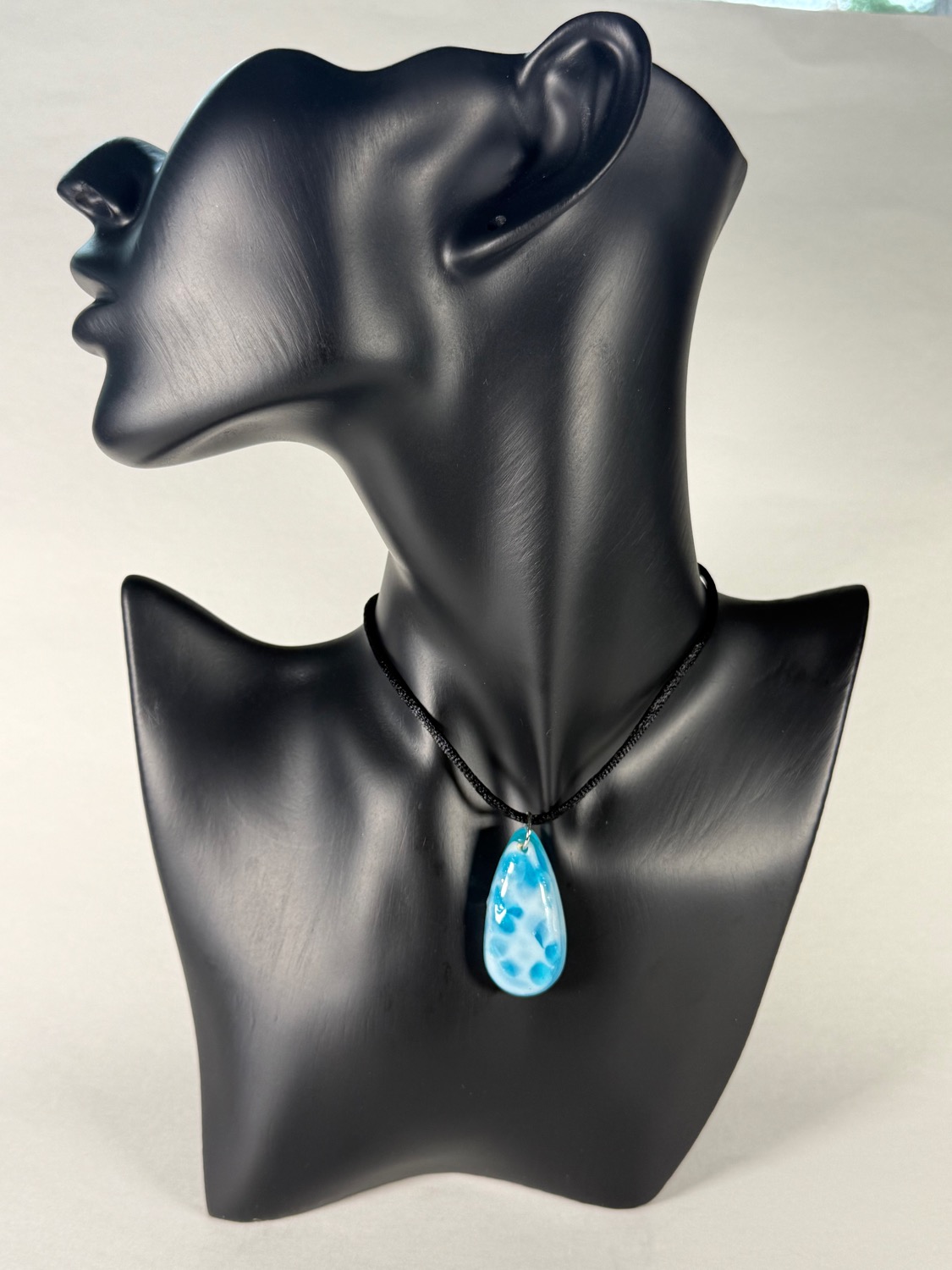 Blue teardrop pendant with dark spot pattern