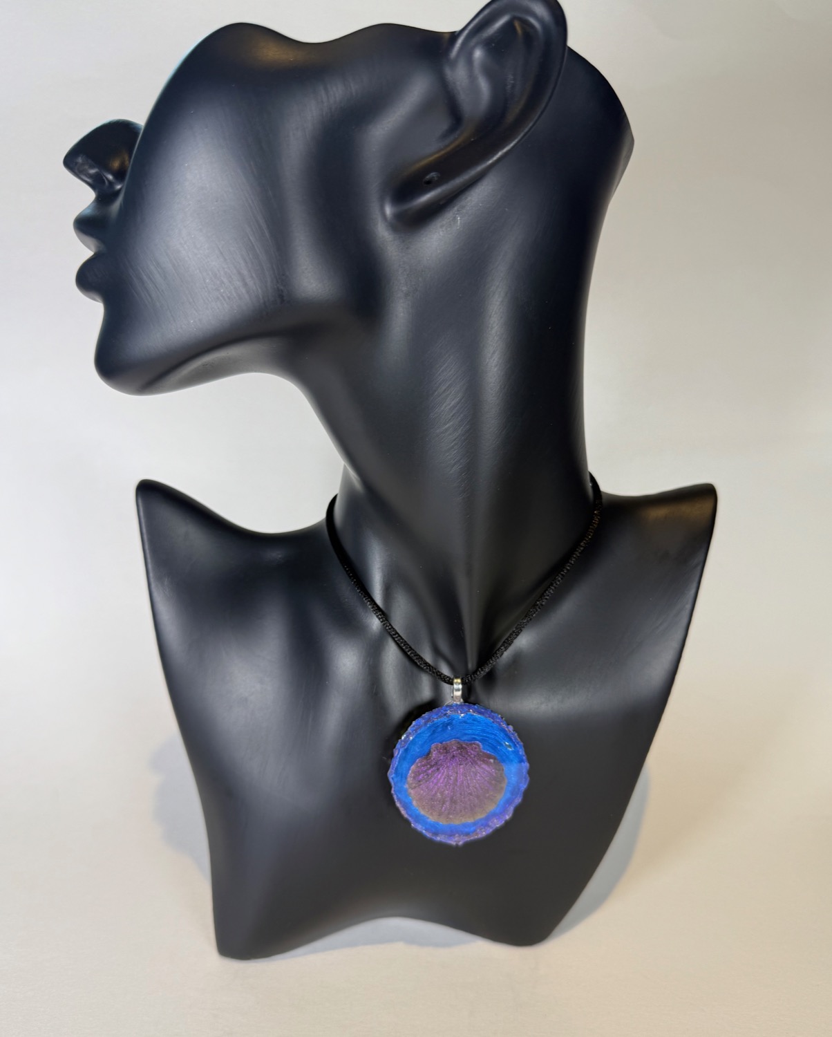 Round pendant with blue geode border and purple scallop shell