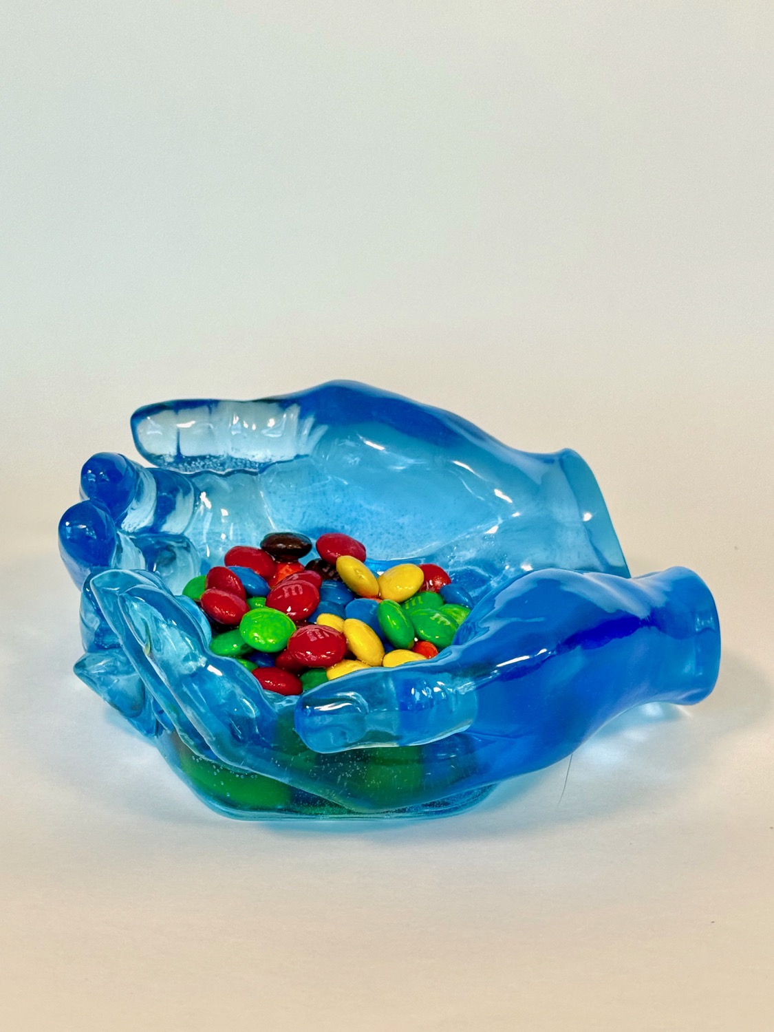 Candy Hands — blue transparent resin hands holding M&Ms