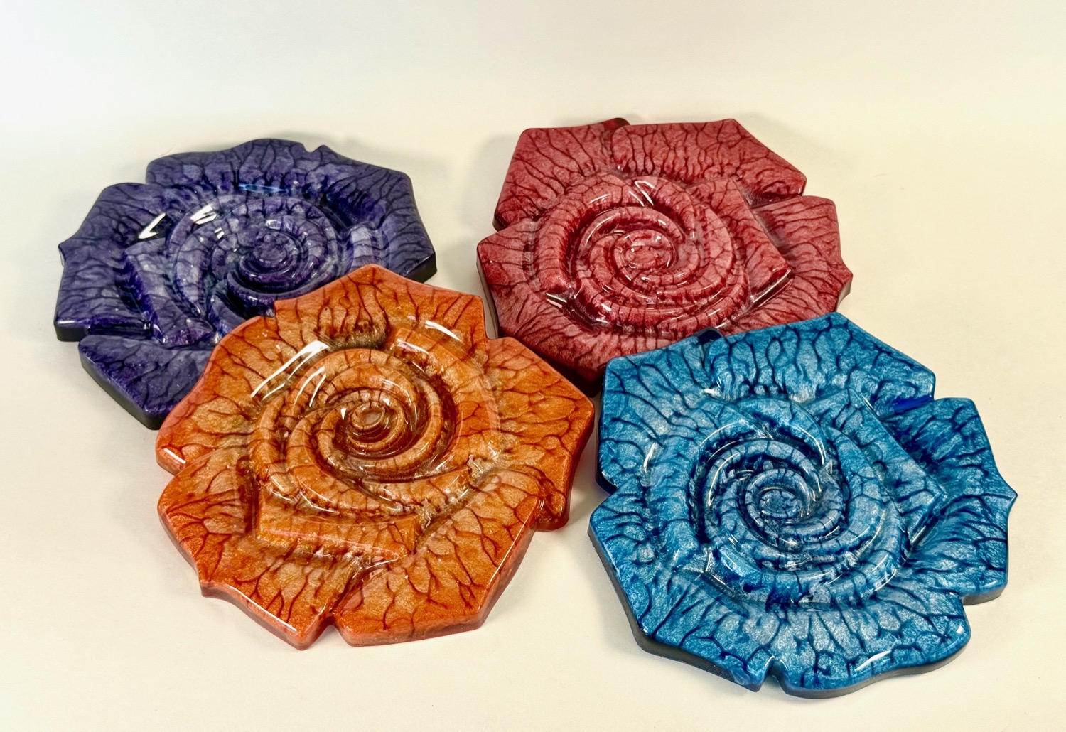 Set of 4 rose-shaped coasters in purple, red, orange, and blue