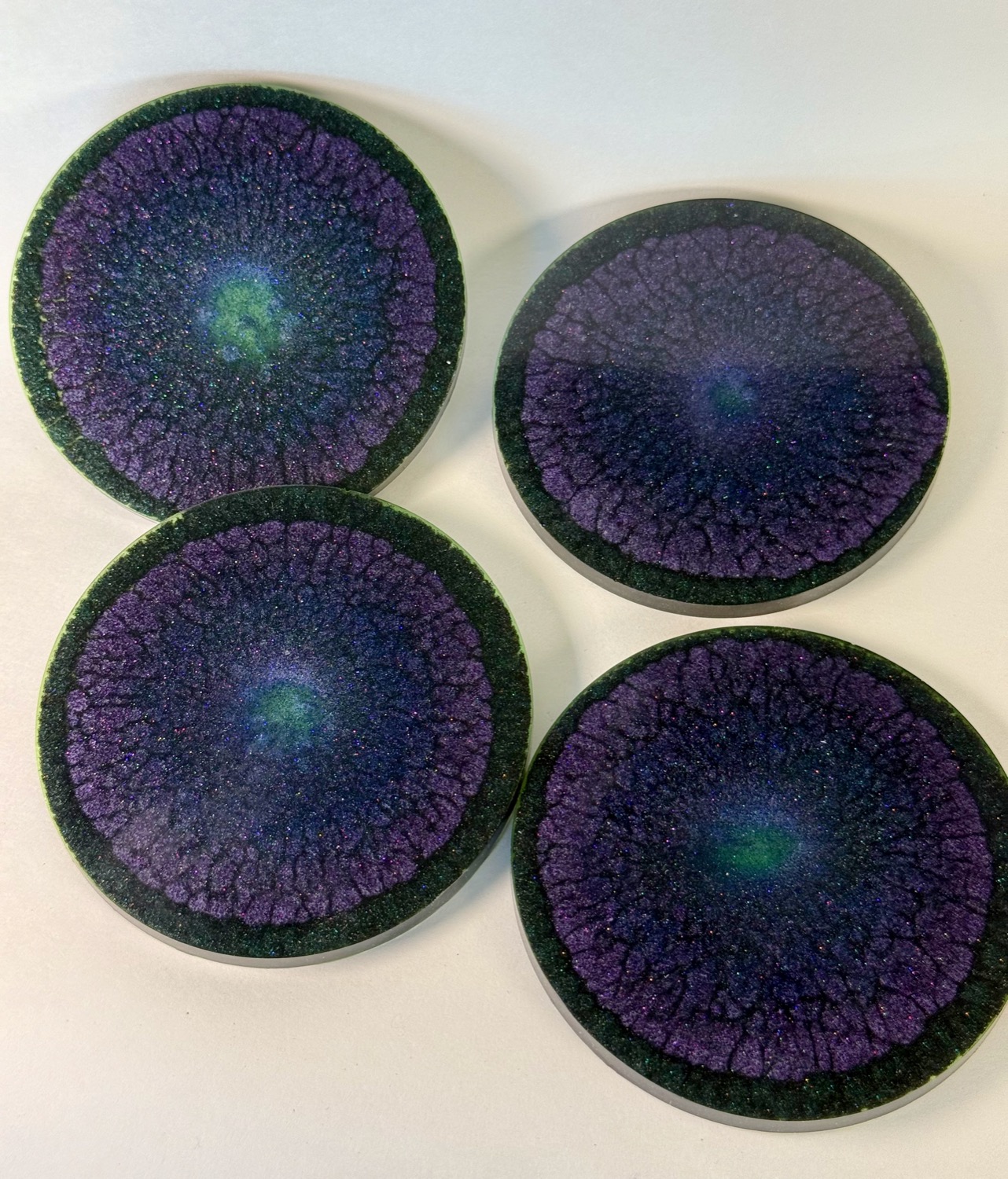 Set of 4 dark purple resin coasters with green nebula glow and sparkles