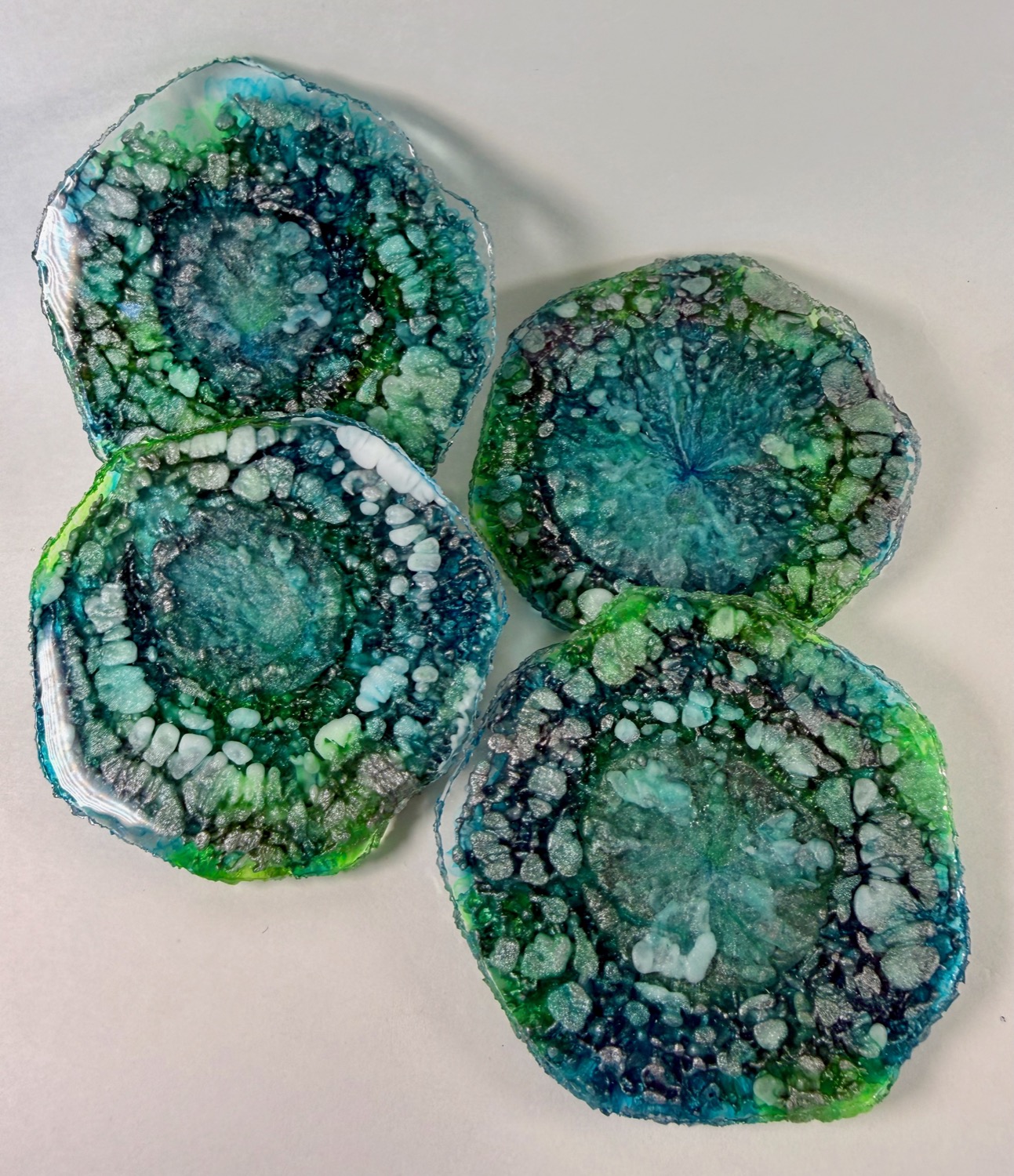 Set of 4 teal green geode resin coasters with silver druzy crystal edges