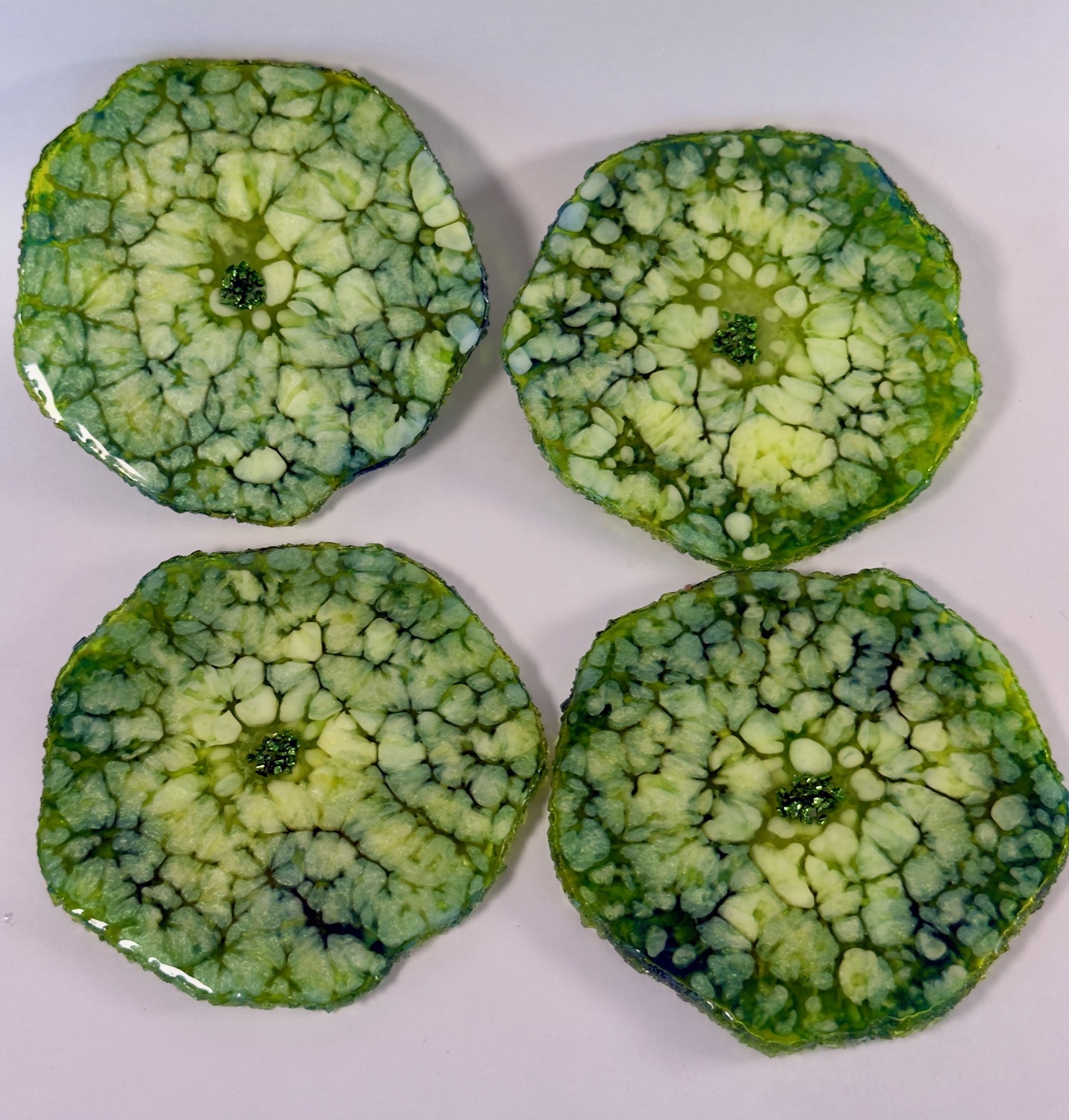 Set of 4 green cellular geode resin coasters with green glitter centres