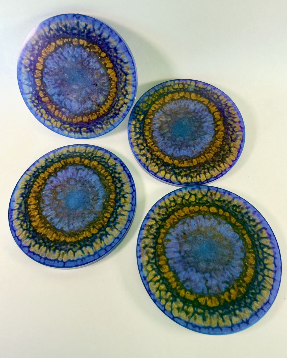 Set of 4 round resin coasters with purple, cobalt and gold mandala sunburst pattern