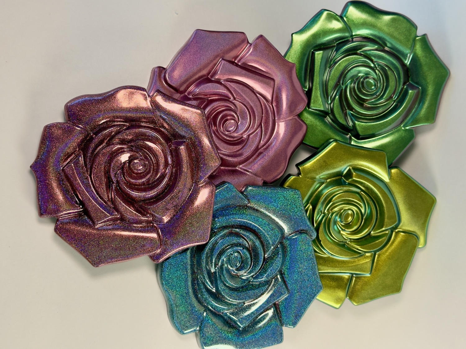 Set of 5 metallic iridescent rose-shaped resin coasters in purple, green, blue and pink
