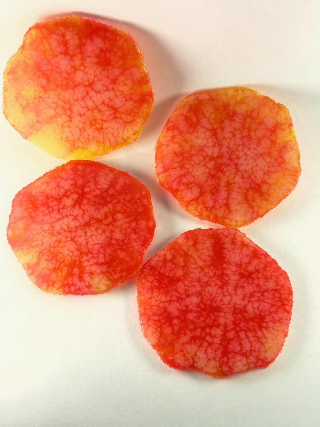 Set of 4 orange and red resin coasters with marbled web vein pattern