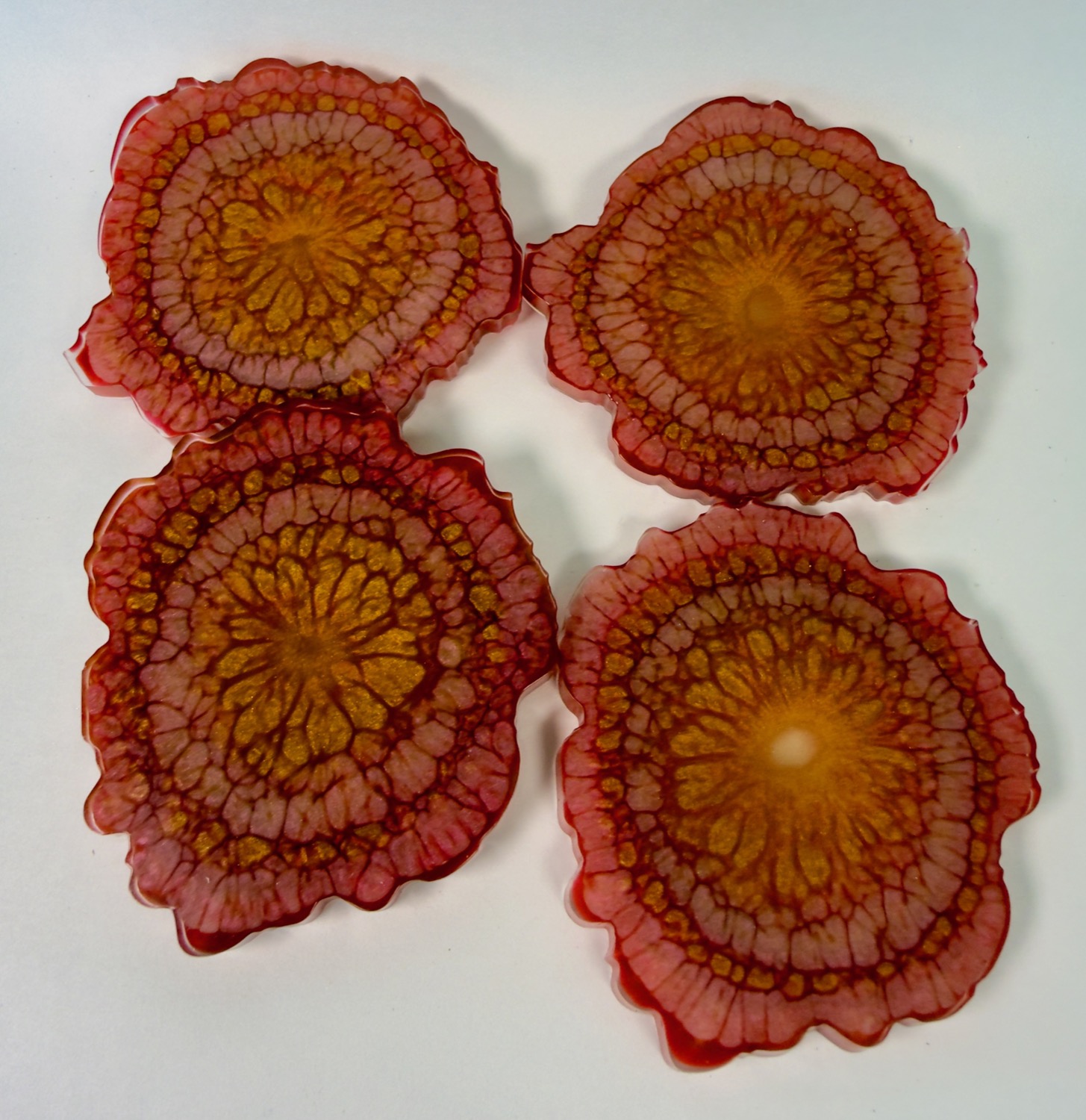 Set of 4 red and orange resin coasters with gold mandala sunburst centres