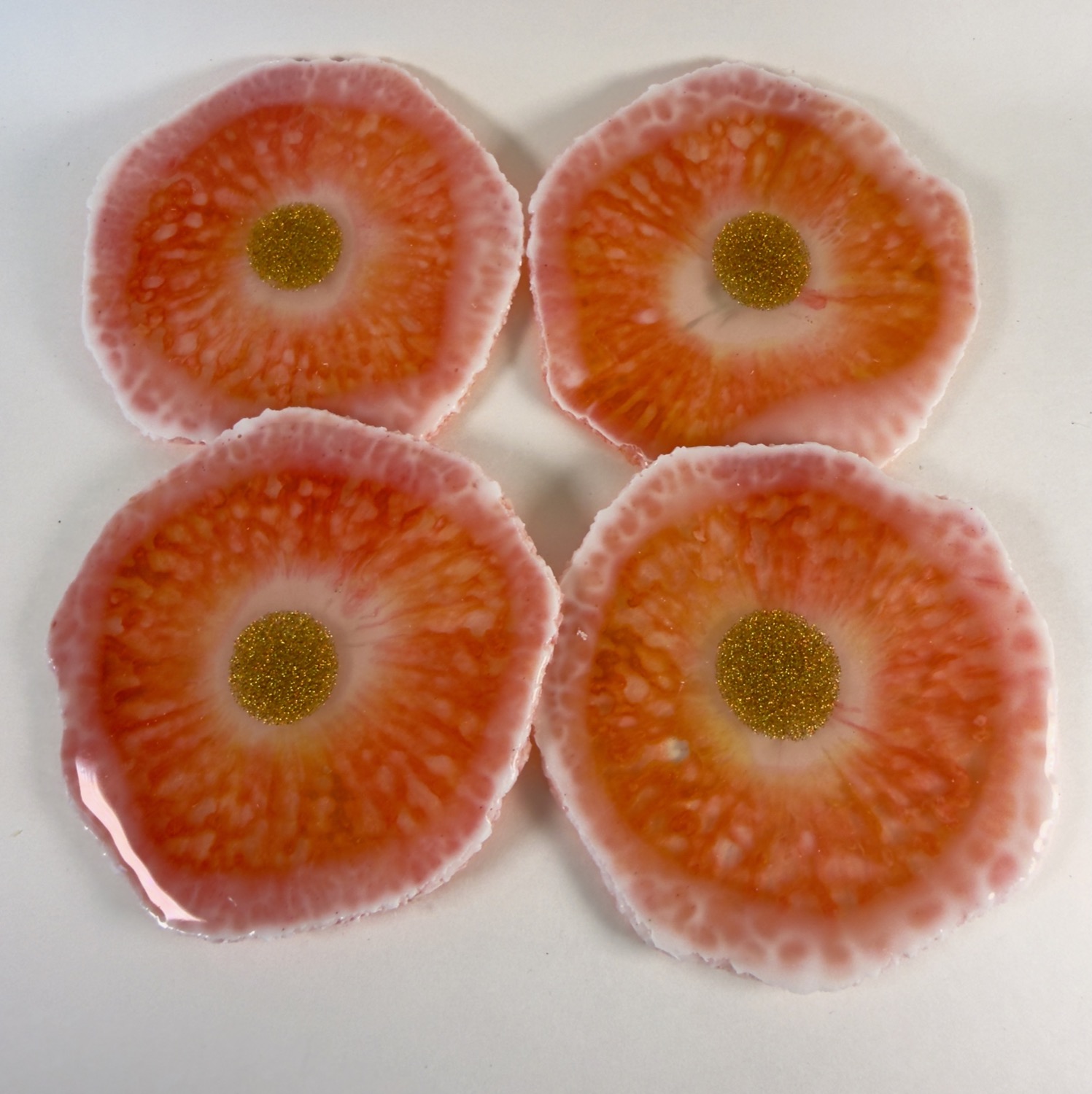 Set of 4 coral and peach resin coasters with white crystal edges and gold glitter centres