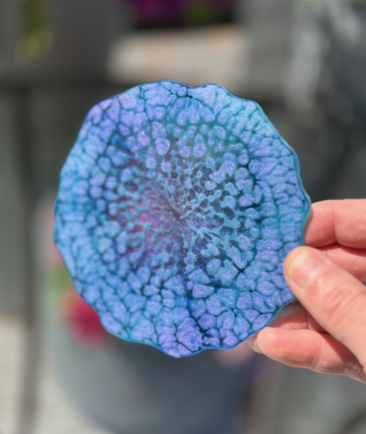 Peacock Blossom coaster held in hand outdoors