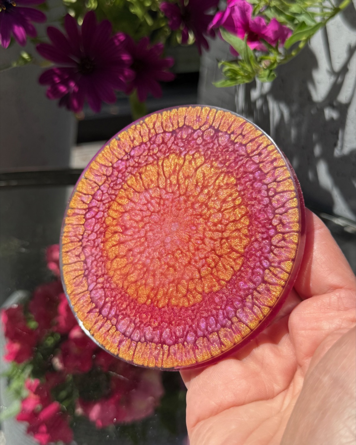 Sunset Mandala coaster held in hand outdoors